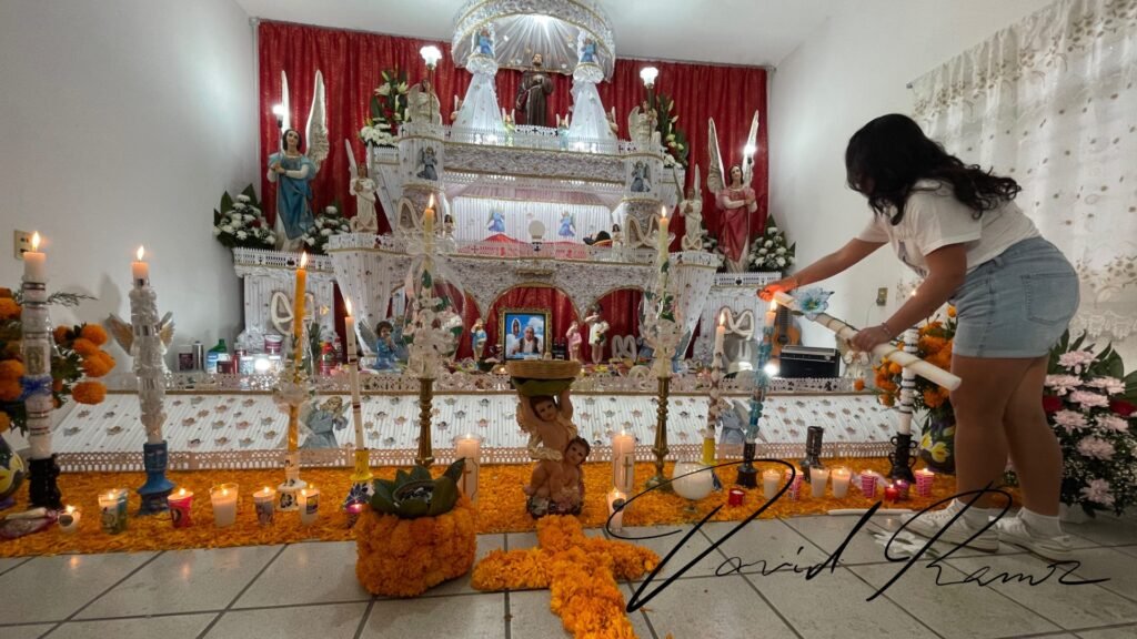 Altar monumental de Huaquechula con velas, ángeles y tapete de cempasúchil dentro de una casa