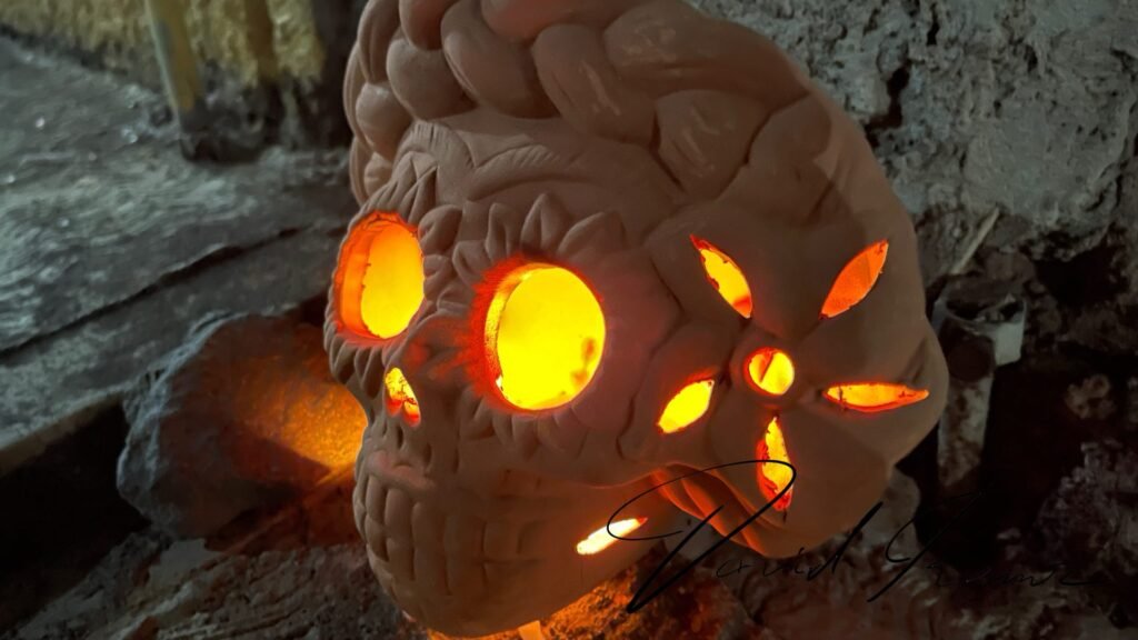 Calavera de barro iluminada desde dentro durante el Día de Muertos en Huaquechula