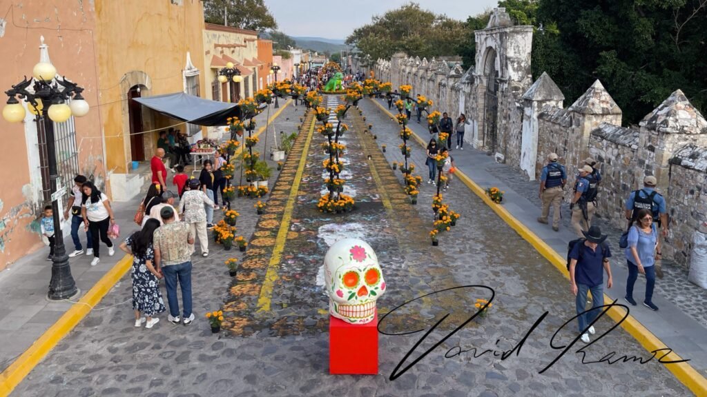 Calle de Huaquechula decorada con arcos de cempasúchil y tapete floral para Día de Muertos